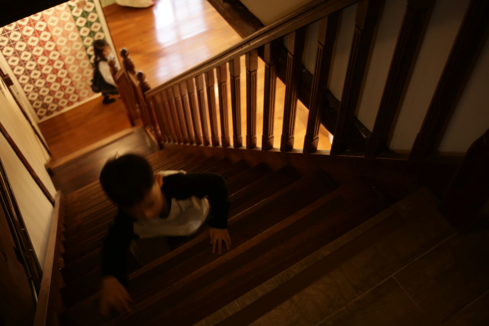 Little boy crawling up wooden stairs, showing why families need the best baby gates